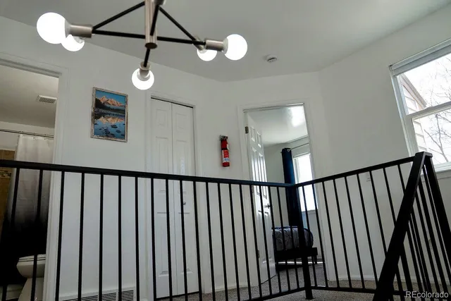 a view of hallway with a window and a chandelier