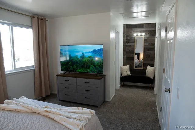 a bedroom with a bed and a television