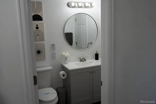 a bathroom with a toilet a sink and mirror