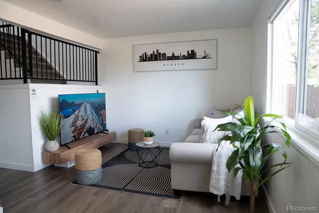 a living room with furniture flowerpot and wooden floor