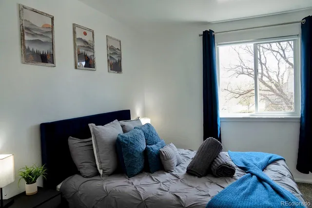 a bed sitting in a bedroom next to a window