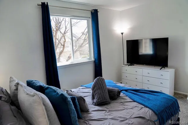 a bedroom with a bed tv and window