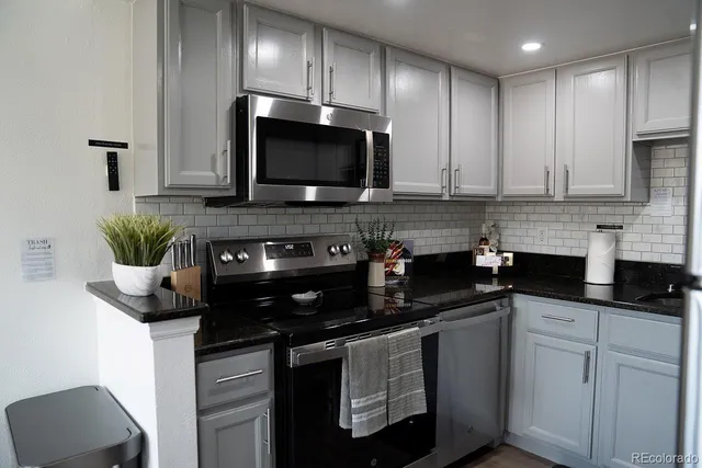 a kitchen with stainless steel appliances granite countertop a sink and a stove