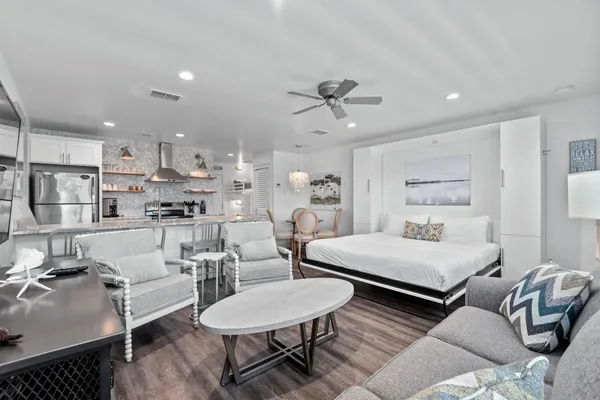 a living room with furniture and a view of kitchen
