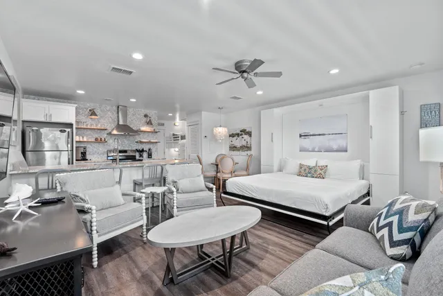 a living room with furniture and a view of kitchen