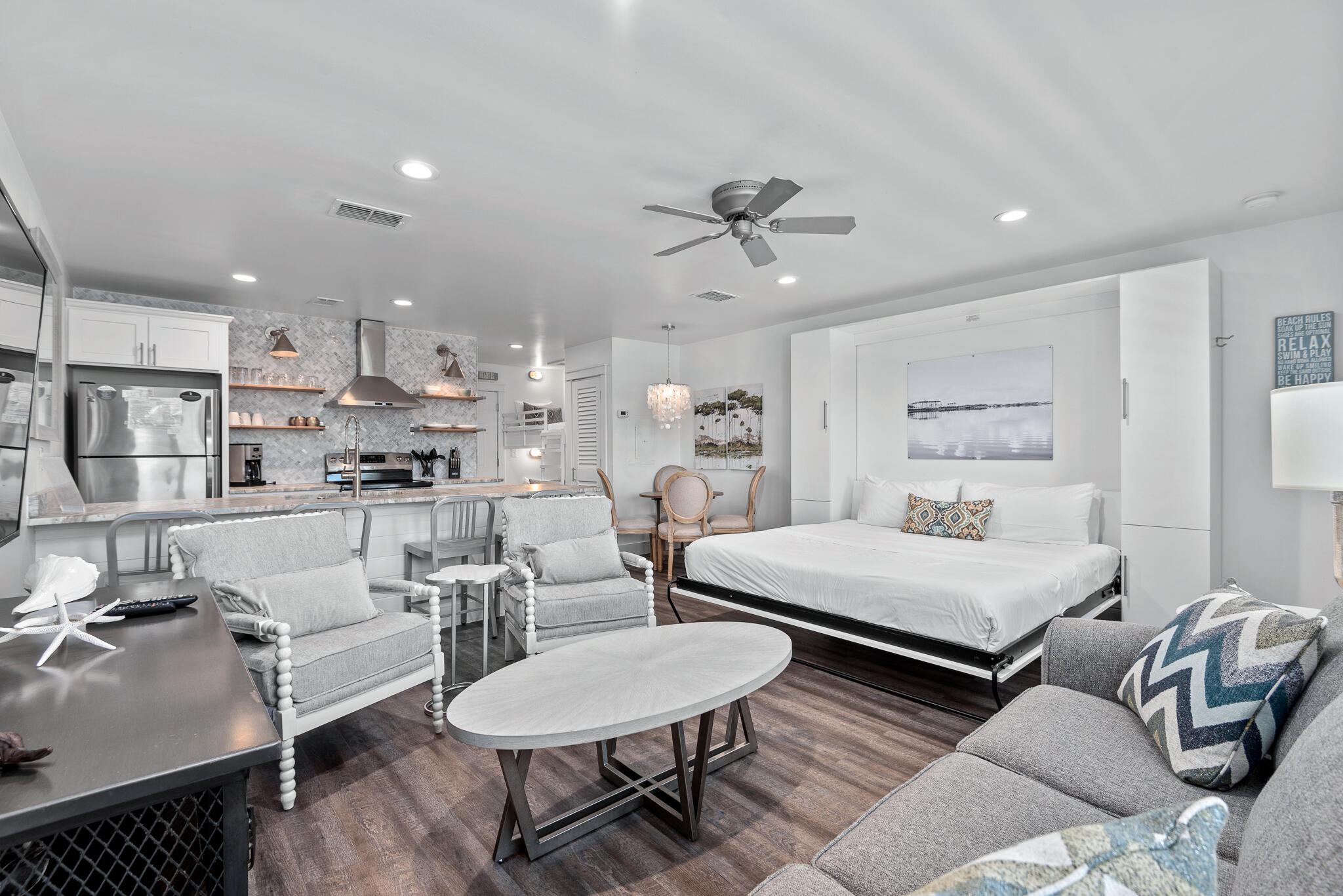 a living room with furniture and a view of kitchen