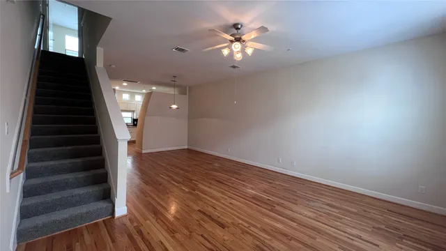 wooden floor in an empty room with a chandelier