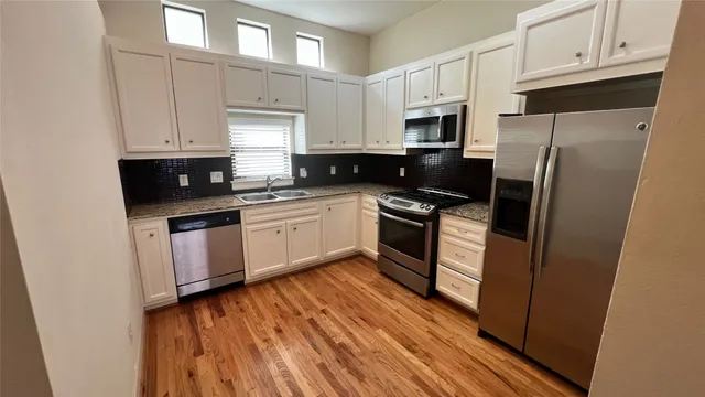 a bathroom with a granite countertop toilet a sink and a mirror