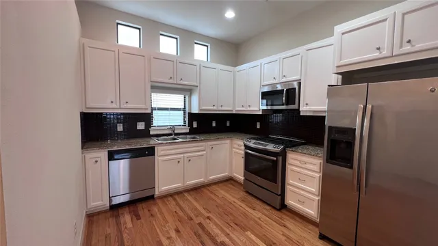 a kitchen with stainless steel appliances granite countertop a stove a sink and a refrigerator