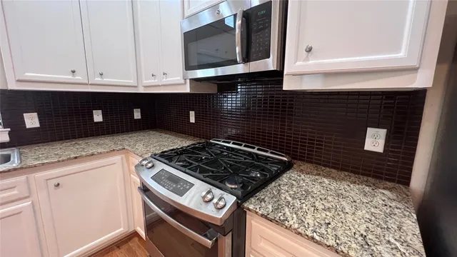a kitchen with white cabinets and appliances