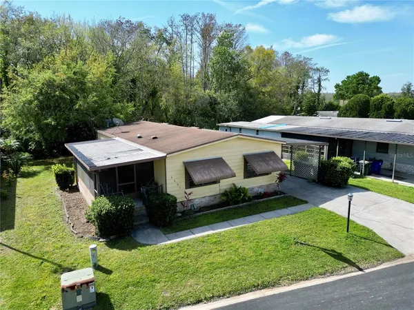 a front view of a house with a garden and trees