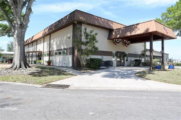 an aerial view of a house with swimming pool and large trees