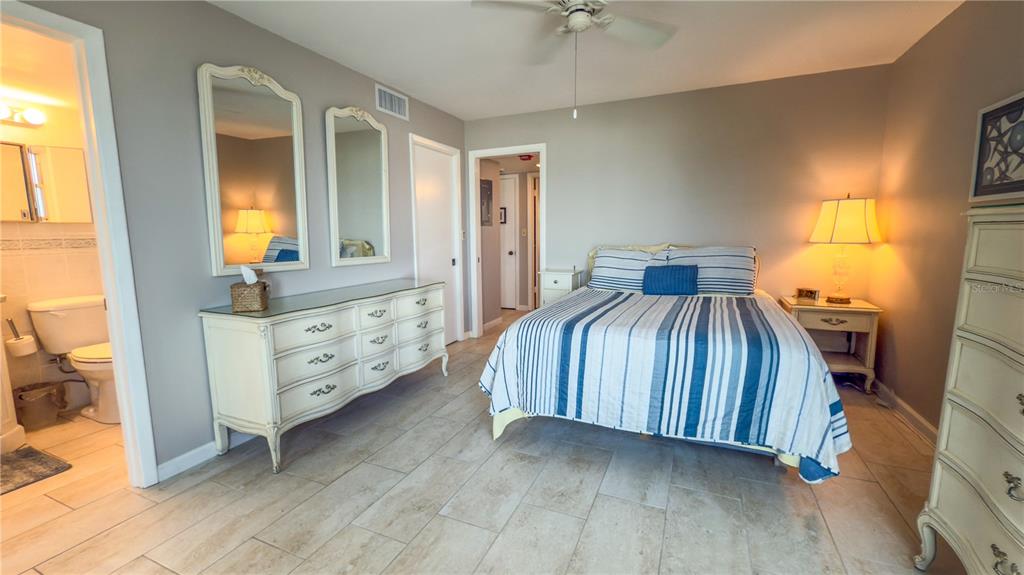 1900 Benjamin Franklin Drive, Unit 201BER Sarasota, FL 34236 - Photo 11 of 21 a bedroom with a bed and a dresser