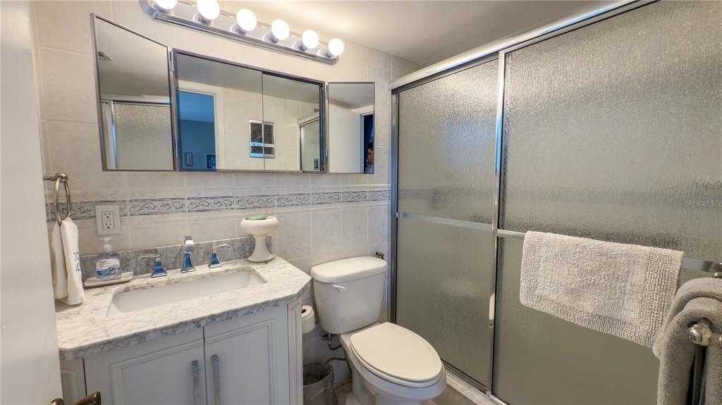 1900 Benjamin Franklin Drive, Unit 201BER Sarasota, FL 34236 - Photo 12 of 21 a bathroom with a granite countertop sink toilet and mirror