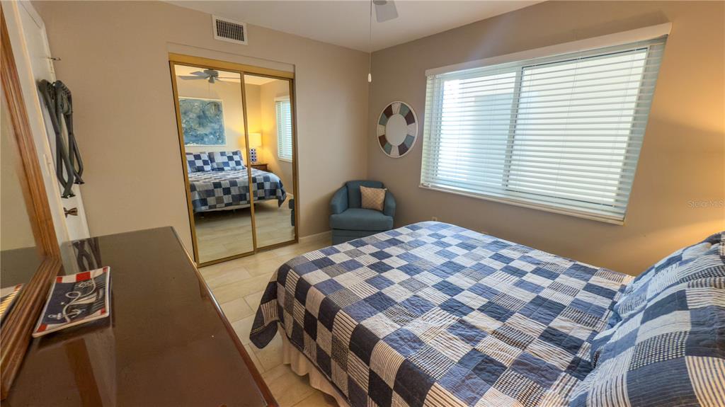 1900 Benjamin Franklin Drive, Unit 201BER Sarasota, FL 34236 - Photo 14 of 21 a bedroom with a bed and wooden floor