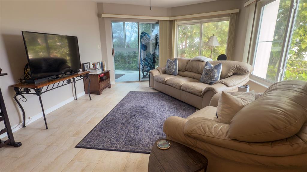 1900 Benjamin Franklin Drive, Unit 201BER Sarasota, FL 34236 - Photo 4 of 21 a living room with furniture and a flat screen tv