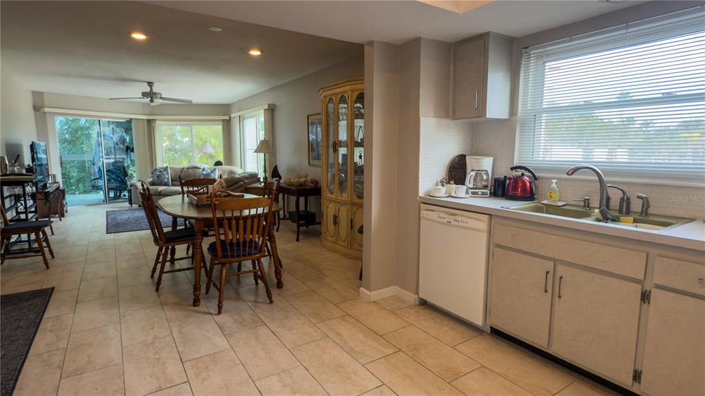 1900 Benjamin Franklin Drive, Unit 201BER Sarasota, FL 34236 - Photo 5 of 21 a dining hall with stainless steel appliances a table chairs refrigerator and sink