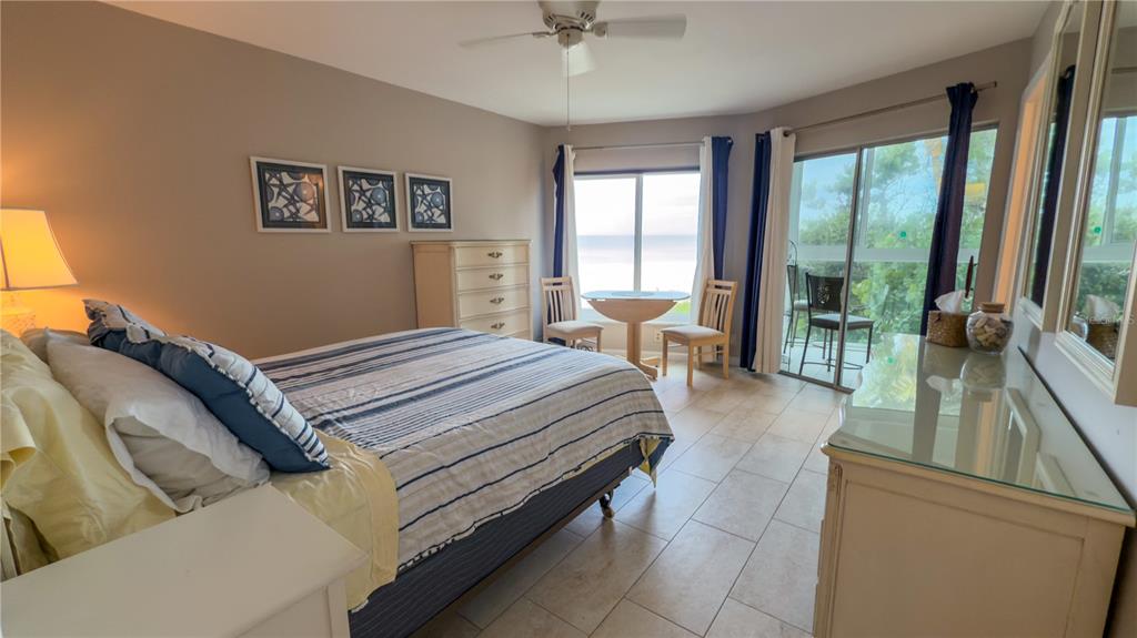 1900 Benjamin Franklin Drive, Unit 201BER Sarasota, FL 34236 - Photo 10 of 21 a bedroom with a bed and glass walk in closet