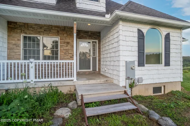 an empty room with wooden floor fireplace and windows