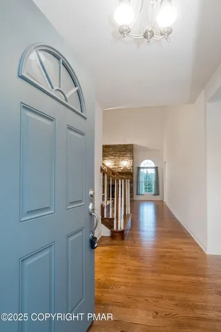 an empty room with wooden floor fireplace and windows