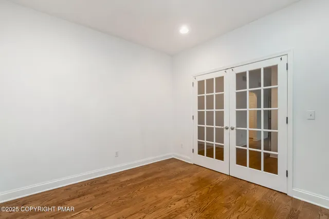 a view of a hallway with wooden floor and a chandelier