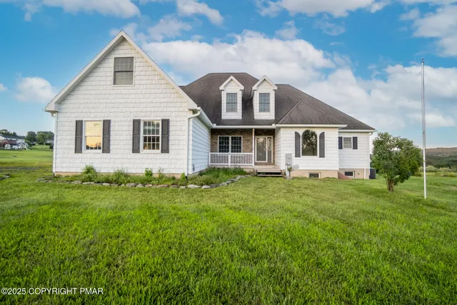 a view of a yard in front of a house with plants and large tree