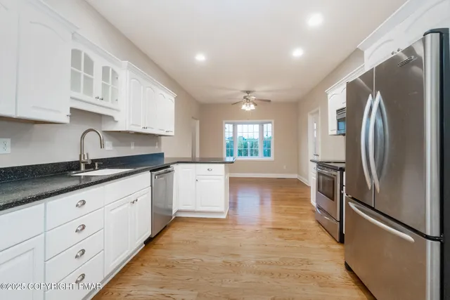 a kitchen with stainless steel appliances granite countertop a sink stove and cabinets