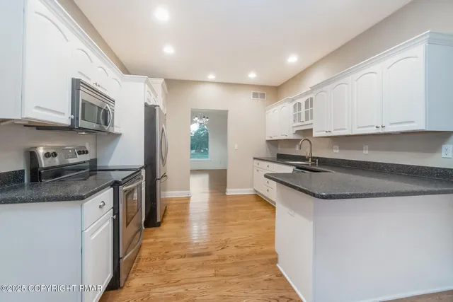 a view of a kitchen with a sink and stainless steel appliances