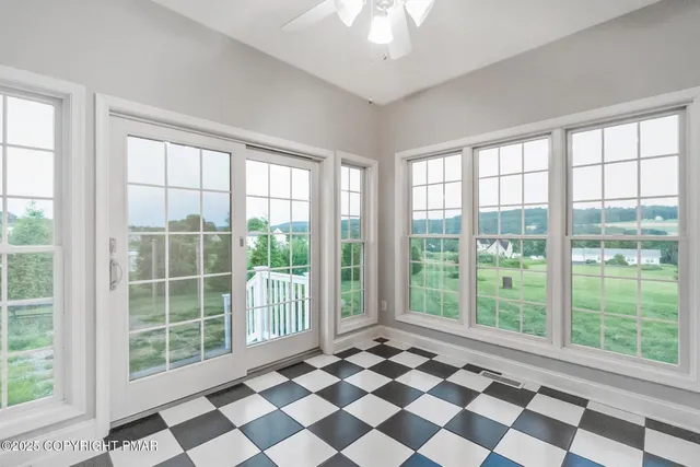 a view of an empty room with a window and a kitchen