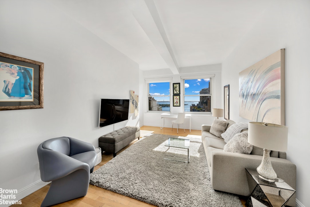 88 Greenwich Street, Unit 2704 Manhattan, NY 10006 - Photo 2 of 12 a living room with furniture and a flat screen tv