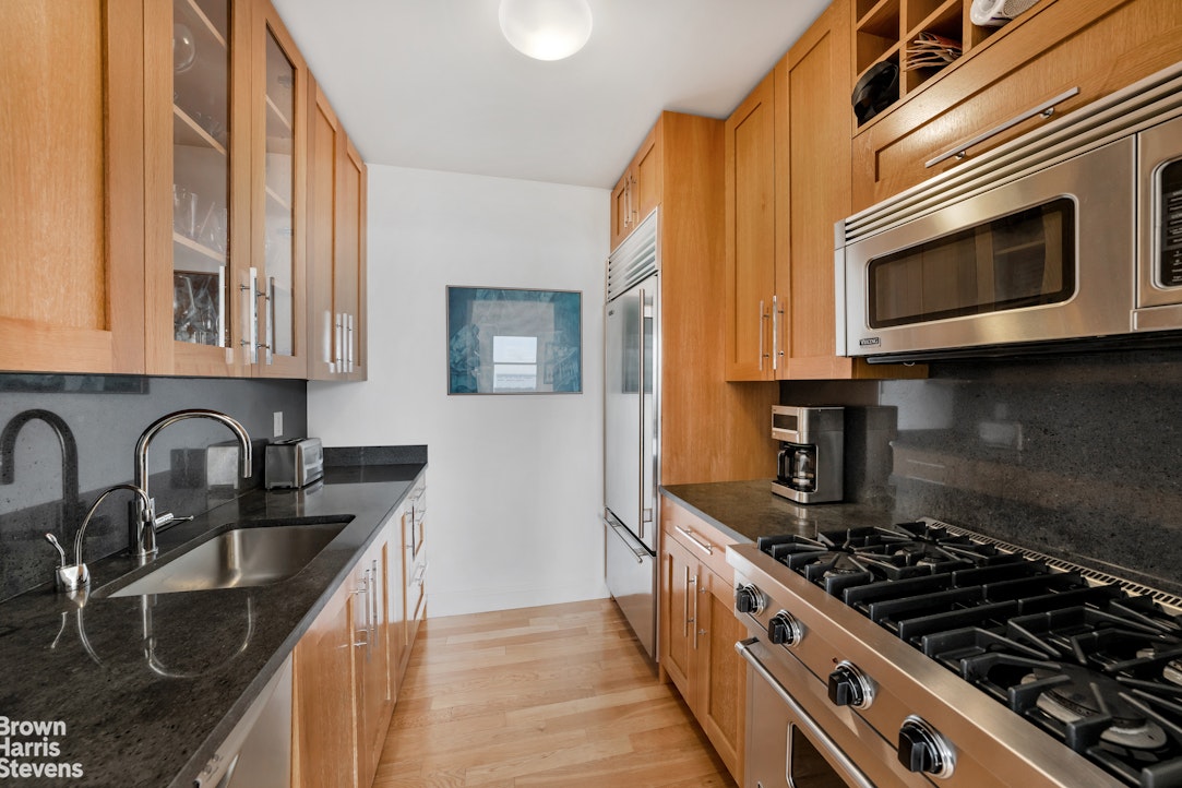 88 Greenwich Street, Unit 2704 Manhattan, NY 10006 - Photo 5 of 12 a kitchen with stainless steel appliances granite countertop a stove and a microwave