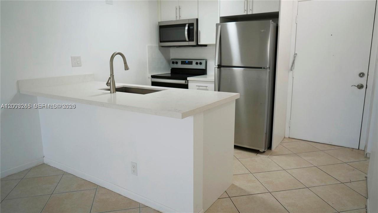 a kitchen with a refrigerator and a sink