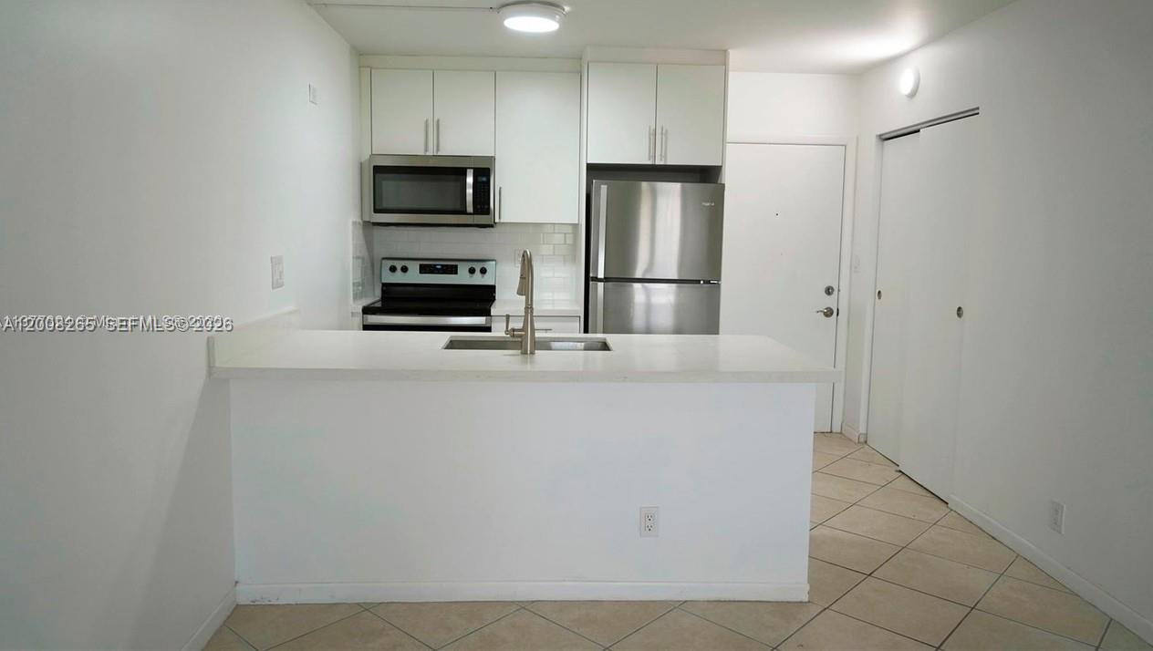 2771 Riverside Drive, Unit 405A Coral Springs, FL 33065 - Photo 7 of 19 a kitchen with cabinets and stainless steel appliances