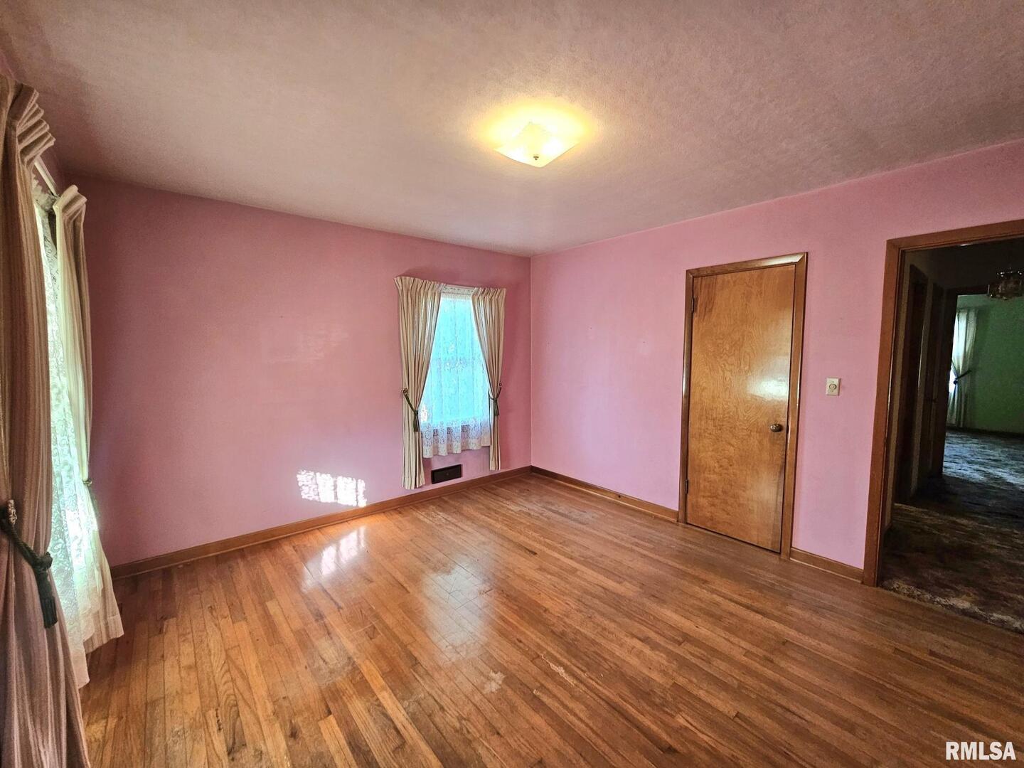 918 Seminary Street Wilton, IA 52778 - Photo 11 of 12 a view of an empty room with wooden floor and a window