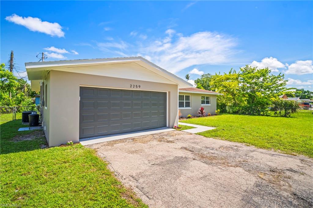 2259 Carrell Road Fort Myers, FL 33901 - Photo 3 of 28 a view of yellow house with small yard and a large tree
