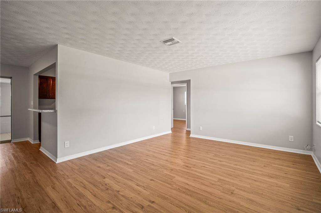 2259 Carrell Road Fort Myers, FL 33901 - Photo 4 of 28 a view of an empty room with wooden floor and a window