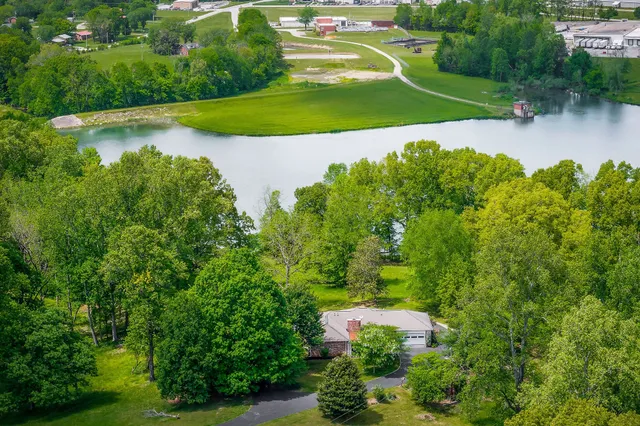 an aerial view of residential houses with outdoor space and trees