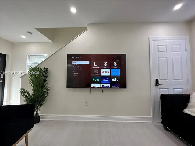 a living room with furniture and a refrigerator