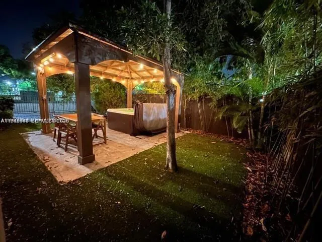 a view of a patio with table and chairs potted plants and large tree