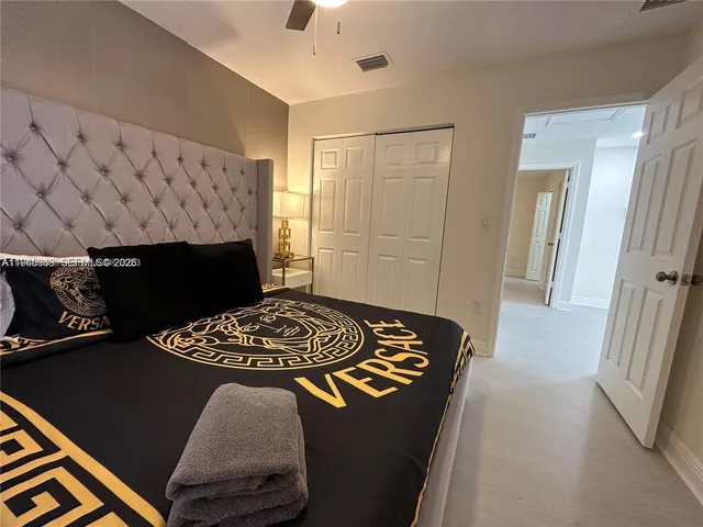 a bed sitting in a bedroom next to a window with a chandelier