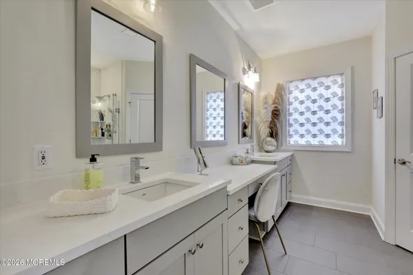 a bathroom with double vanity sinks and a mirror