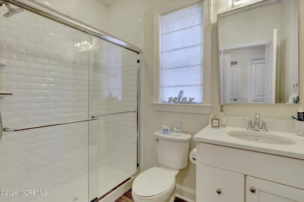 a bathroom with a sink a toilet and shower