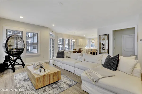 a living room with furniture a large window and a chandelier