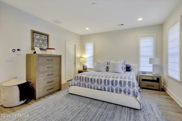 a large bedroom with a bed and wooden floor