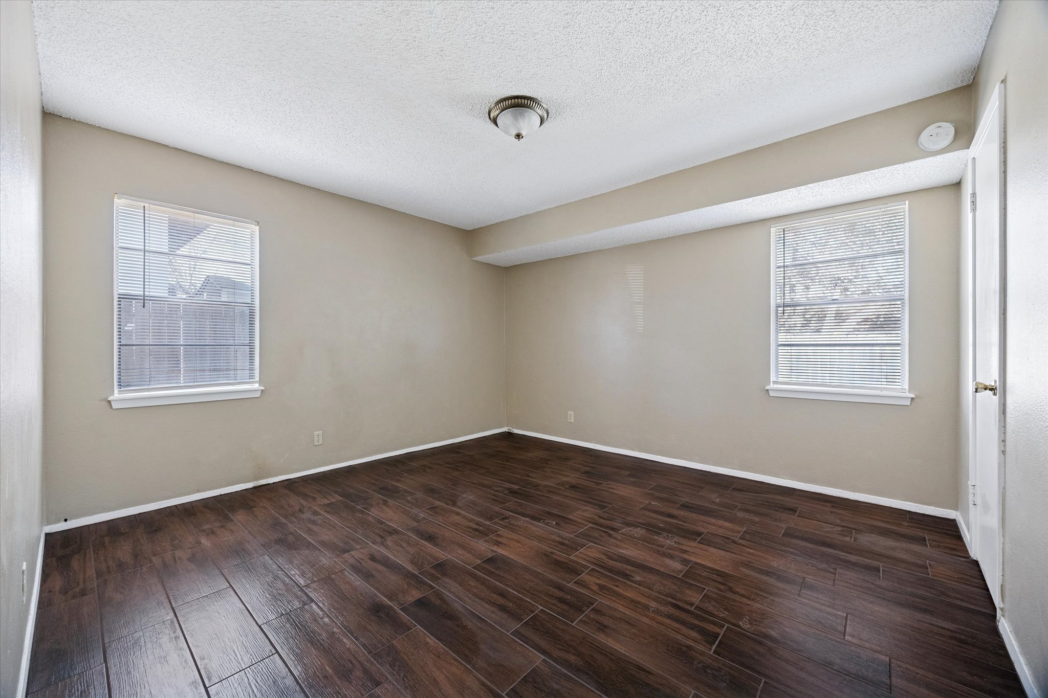 908 Kirschner Place, Unit B Austin, TX 78758 - Photo 6 of 10 a view of an empty room with wooden floor and a window