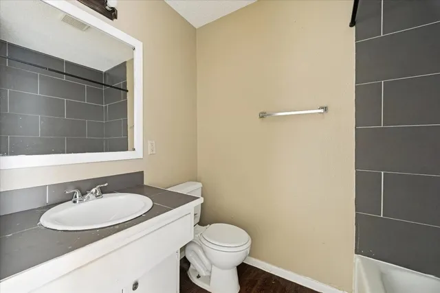 a bathroom with a sink toilet and a mirror