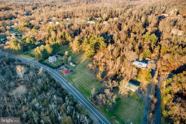 an aerial view of residential houses with outdoor space and trees