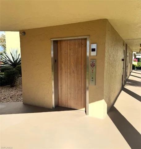 a view of a hallway with wooden floor and a living room