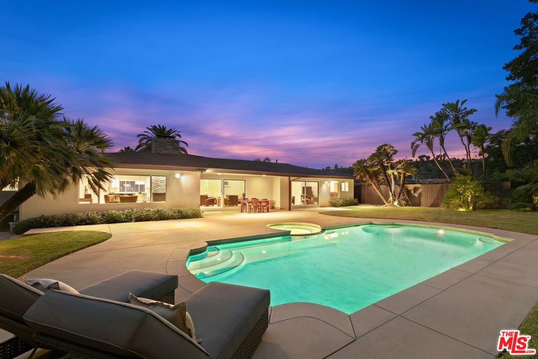 a view of a house with swimming pool and a yard