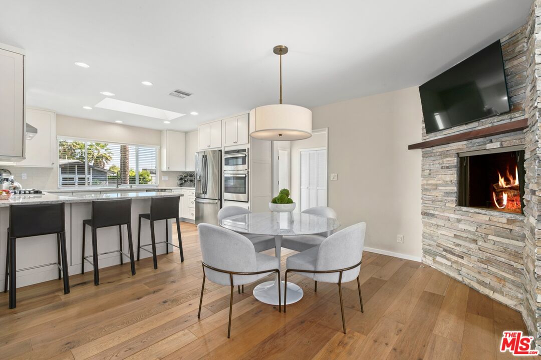 6523 Lakeridge Road Los Angeles, CA 90068 - Photo 11 of 28 a dining room with furniture window fireplace and wooden floor